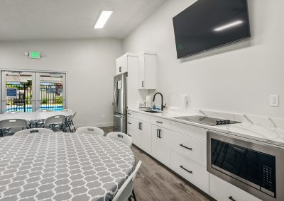 Resident center community kitchen with tables at Timpanogos Village MHC in Orem City, Utah