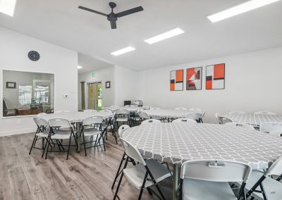 Resident center interior with tables and chairs at Timpanogos Village MHC in Orem City, Utah