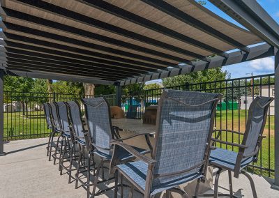 Pergola with table and seating near pool at Timpanogos Village MHC in Orem City, Utah